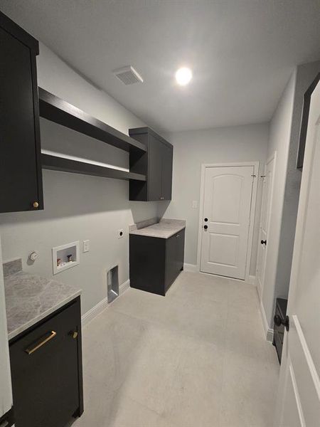 Laundry area featuring electric dryer hookup, washer hookup, and cabinet space