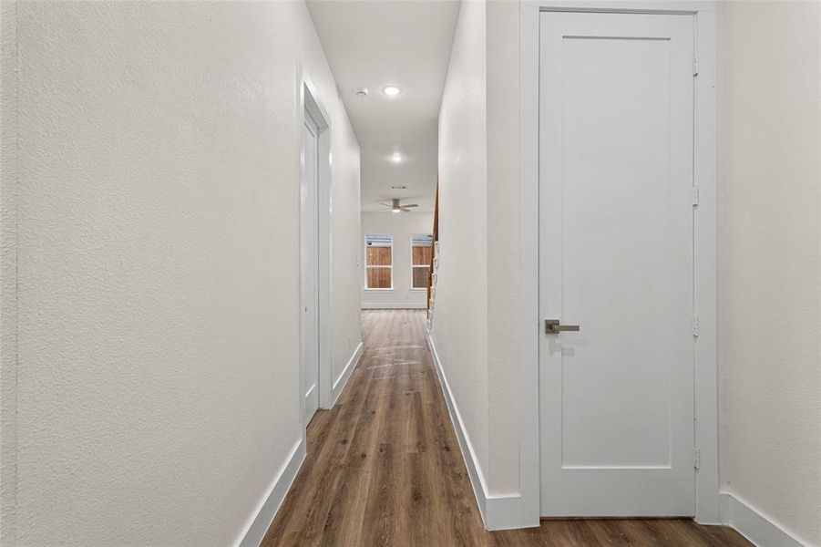 Hallway with recessed lighting and dark wood-style floors Hallway with recessed lighting and dark wood-style floors