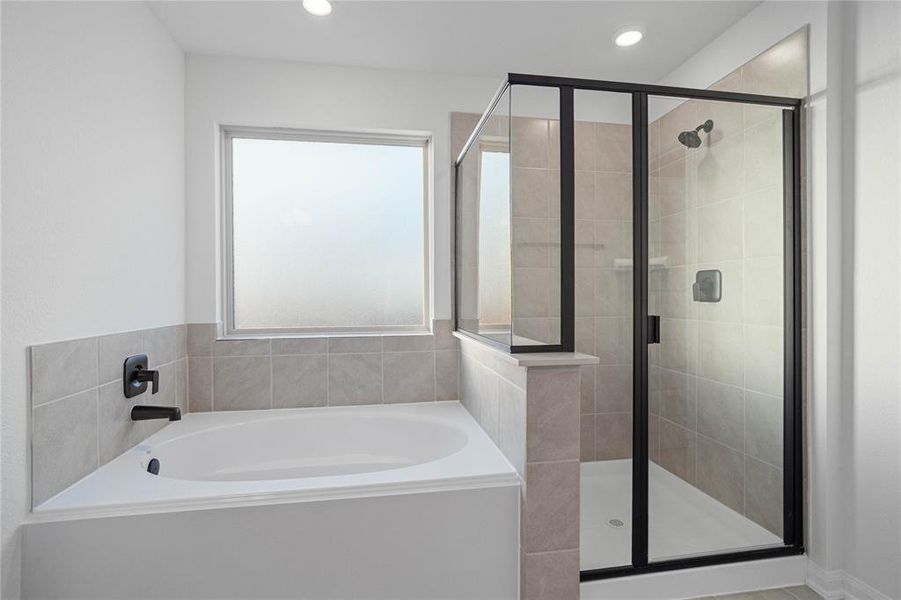 Additional view of the large soaking tub and walk-in shower with tile surround.