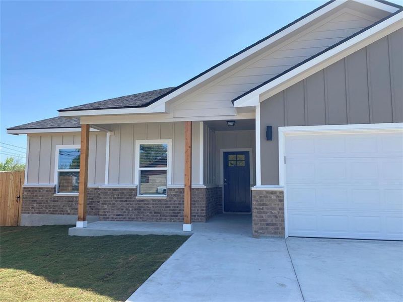 A newly constructed residence showcasing a clean facade of brick and siding with a welcoming front entrance. A newly constructed residence showcasing a clean facade of brick and siding with a welcoming front entrance.