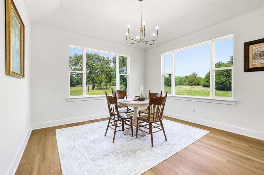 Bright interior space featuring wood-finish flooring and a contemporary chandelier Bright interior space featuring wood-finish flooring and a contemporary chandelier