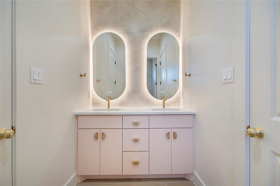 Full bathroom featuring double vanity and baseboards Full bathroom featuring double vanity and baseboards