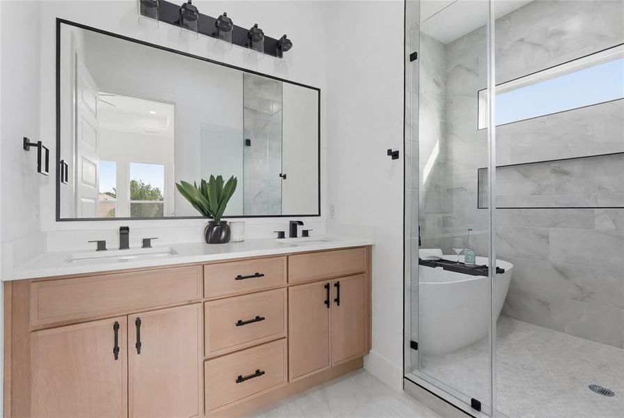 Full bath with double vanity and a stall shower