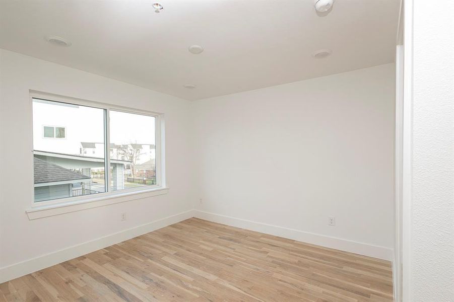 Spare room with light wood-type flooring and baseboards