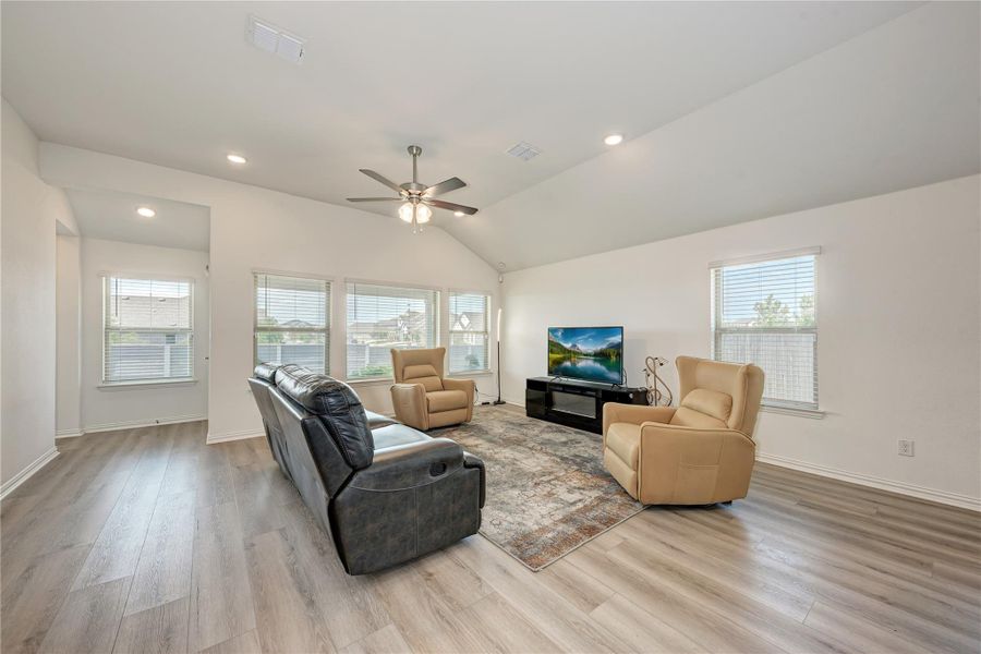 A generous living area presents high vaulted ceilings and resilient flooring, perfect for comfortable gatherings.