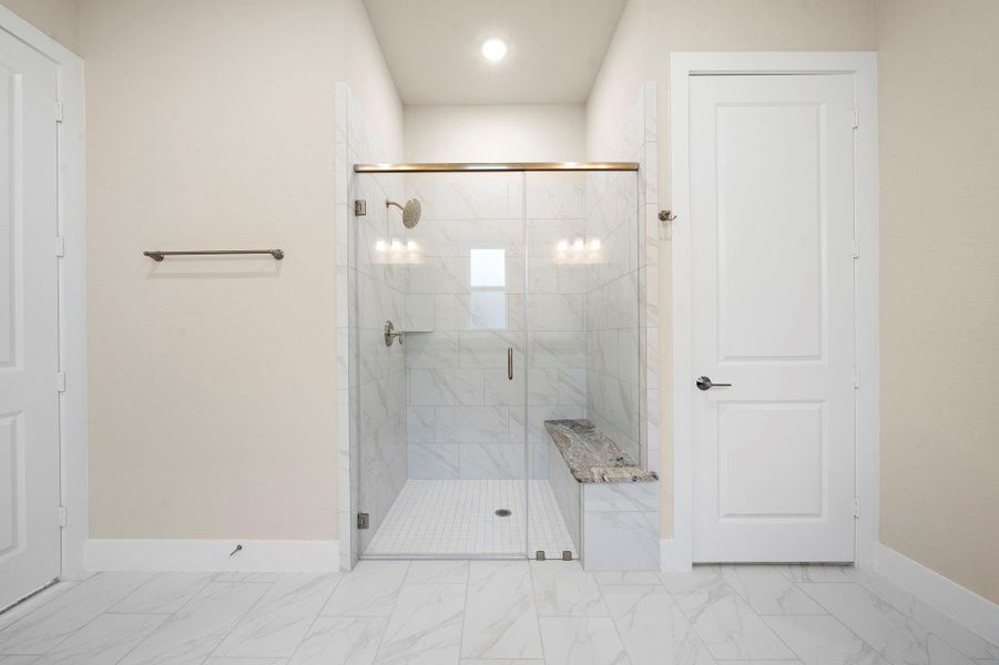 Elegant walk-in shower featuring floor-to-ceiling tile, a built-in bench with granite top, and a sleek frameless glass door — combining style and accessibility. Elegant walk-in shower featuring floor-to-ceiling tile, a built-in bench with granite top, and a sleek frameless glass door — combining style and accessibility.