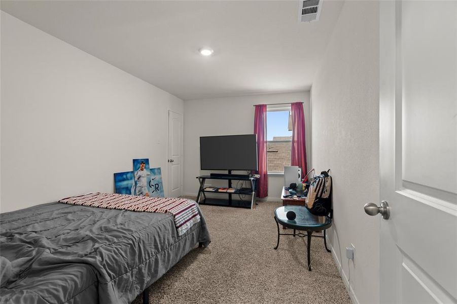 Bedroom with light colored carpet and baseboards