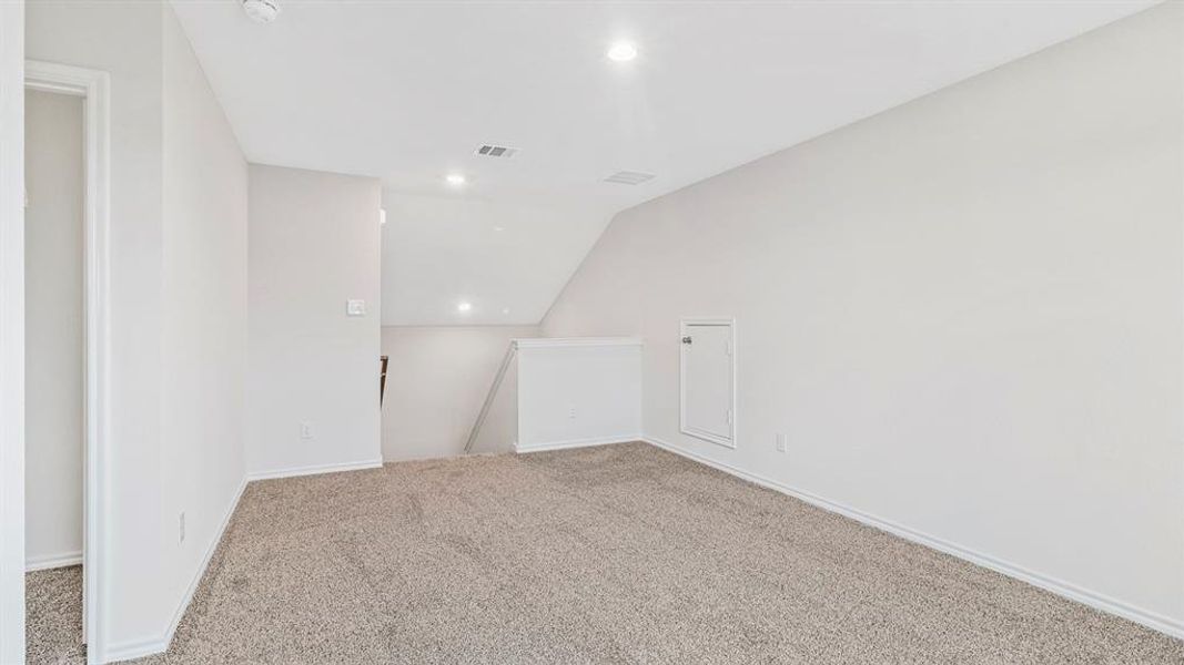 Carpeted upper-level landing with recessed lighting, a white painted railing, and an access panel