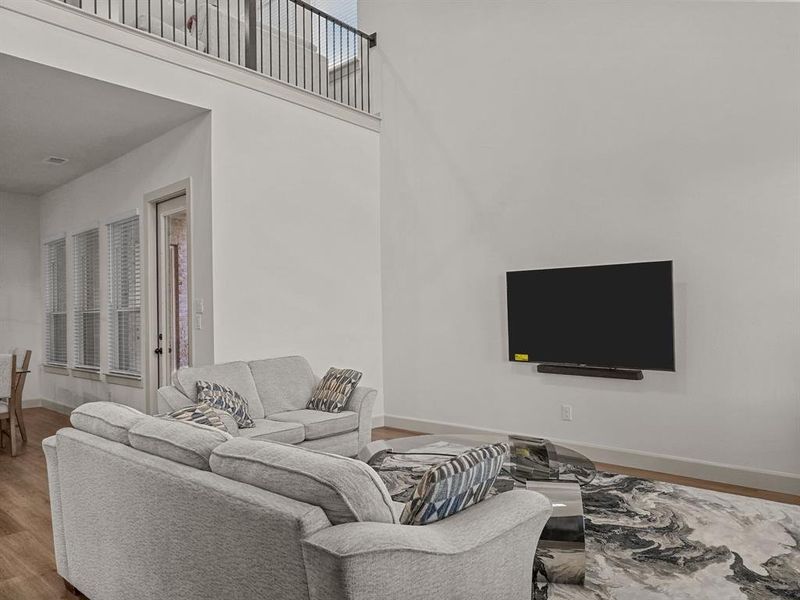 Living room featuring hardwood / wood-style floors and a towering ceiling