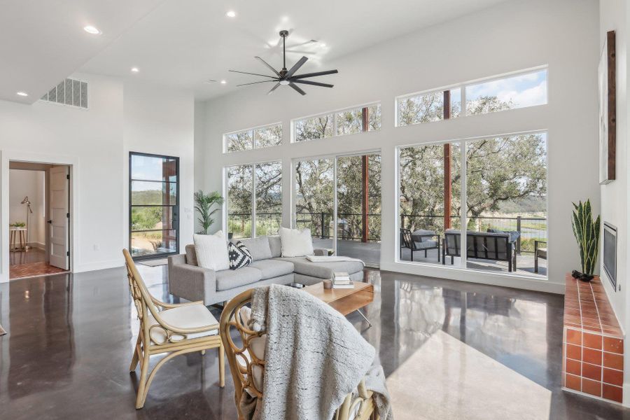 Living area with a towering ceiling, ceiling fan, healthy amount of natural light, recessed lighting, and baseboards Living area with a towering ceiling, ceiling fan, healthy amount of natural light, recessed lighting, and baseboards