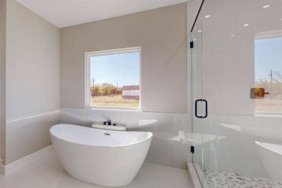 Bathroom featuring tile walls, shower with separate bathtub, and tile patterned flooring