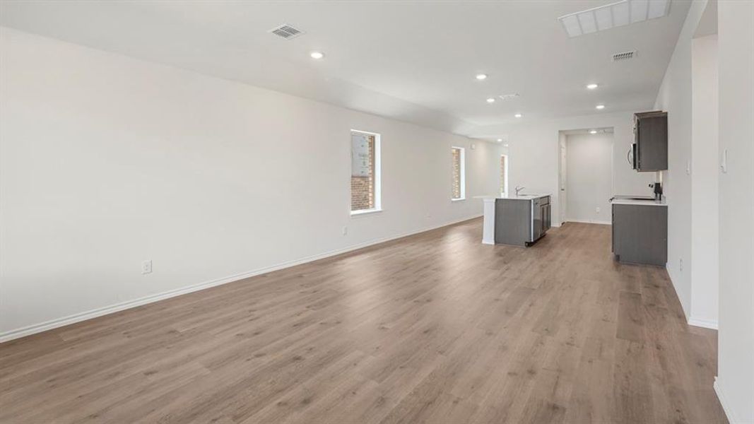 Spacious interior featuring wood-finish flooring, recessed lighting, and white walls