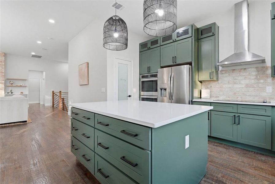 Kitchen island featuring a white countertop and deep green cabinetry with black hardware Kitchen island featuring a white countertop and deep green cabinetry with black hardware