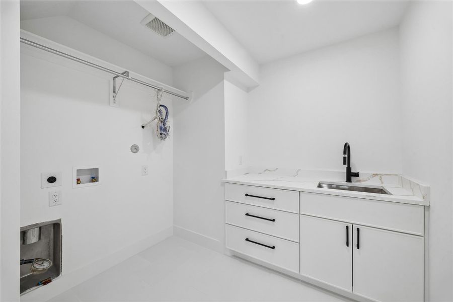 The second-floor utility room includes quartz countertops, built-in cabinetry, and additional storage space designed to support everyday functionality. Positioned near the secondary bedrooms and flex living areas, the layout adds convenience to the upper-level floor plan.