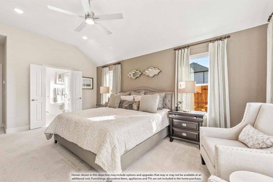 Master bedroom with vaulted ceiling, ceiling fan, carpet floors, and ensuite bathroom access