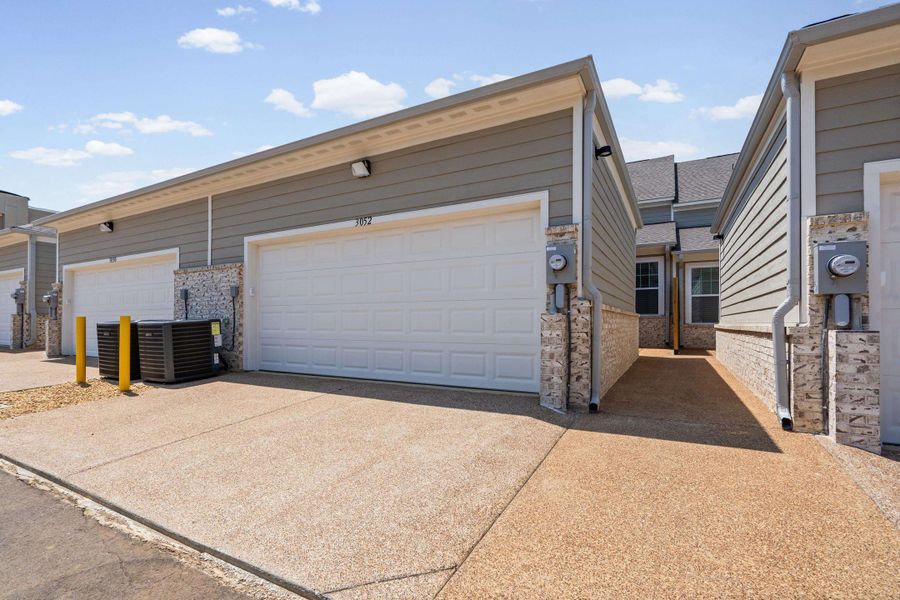 Exterior featuring horizontal siding, white garage doors, decorative stone accents, and concrete driveways Exterior featuring horizontal siding, white garage doors, decorative stone accents, and concrete driveways