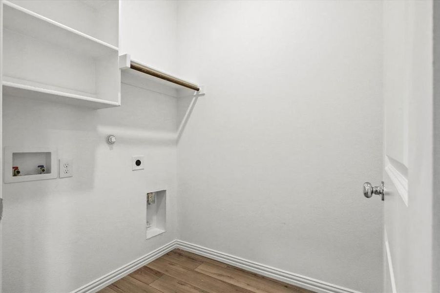 Washroom with wood finished floors, gas dryer hookup, hookup for a washing machine, and hookup for an electric dryer Washroom with wood finished floors, gas dryer hookup, hookup for a washing machine, and hookup for an electric dryer