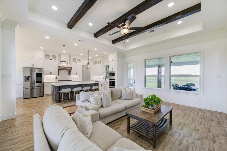 Open living and kitchen area with large windows showcasing backyard views