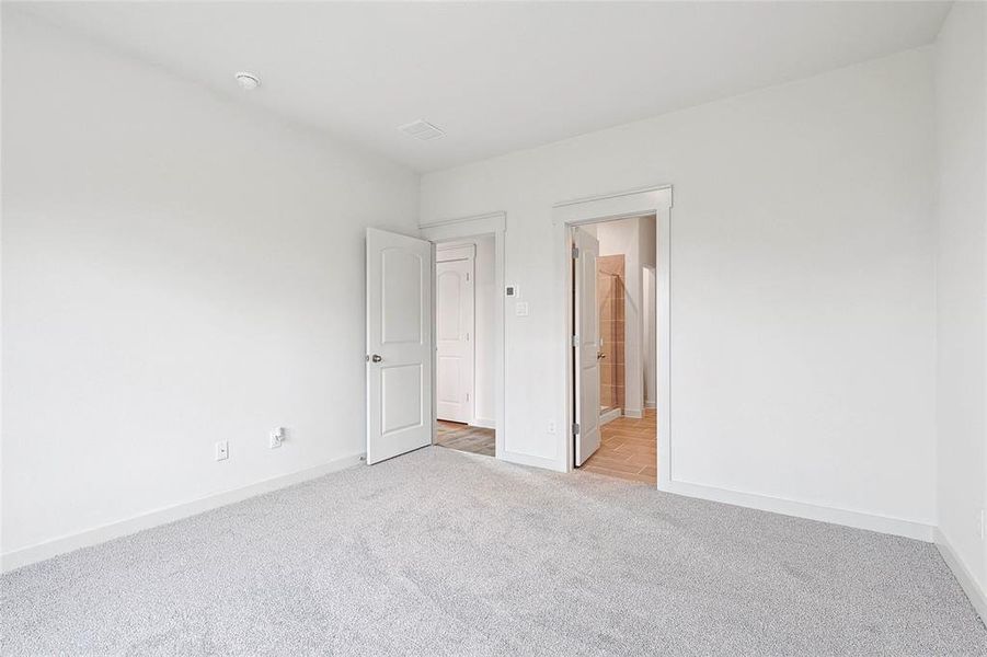 Unfurnished bedroom with light colored carpet