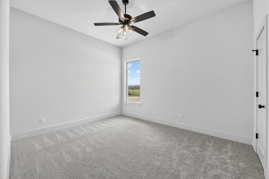 Empty room with light carpet and ceiling fan