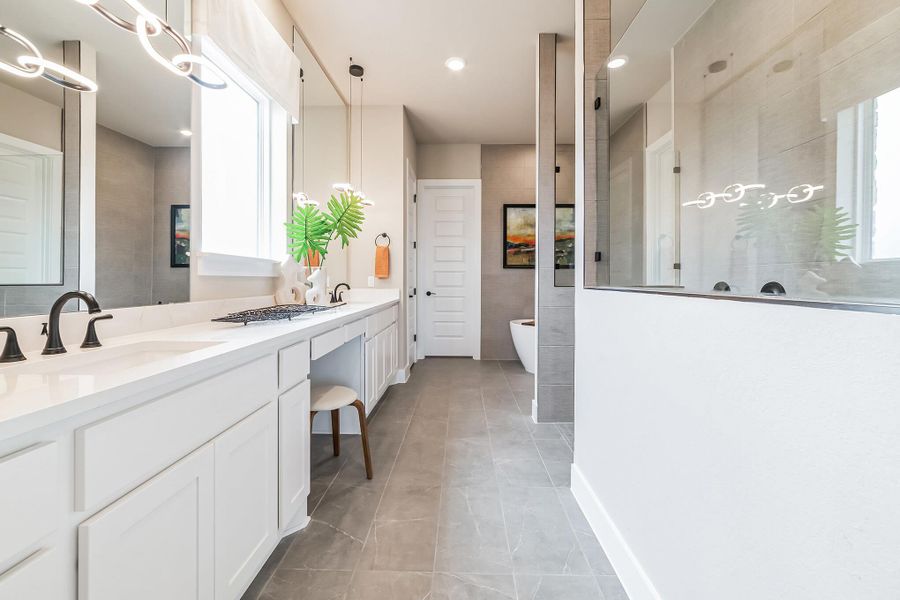 Full bath featuring double vanity, walk in shower, a soaking tub, and recessed lighting