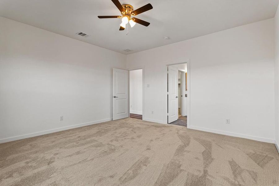 Master bedroom featuring carpet flooring and ceiling fan