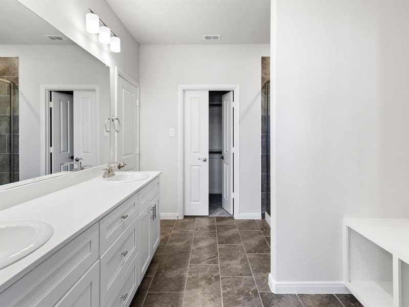 The owner's bath of your dreams features his and her vanities and spacious walk in shower!