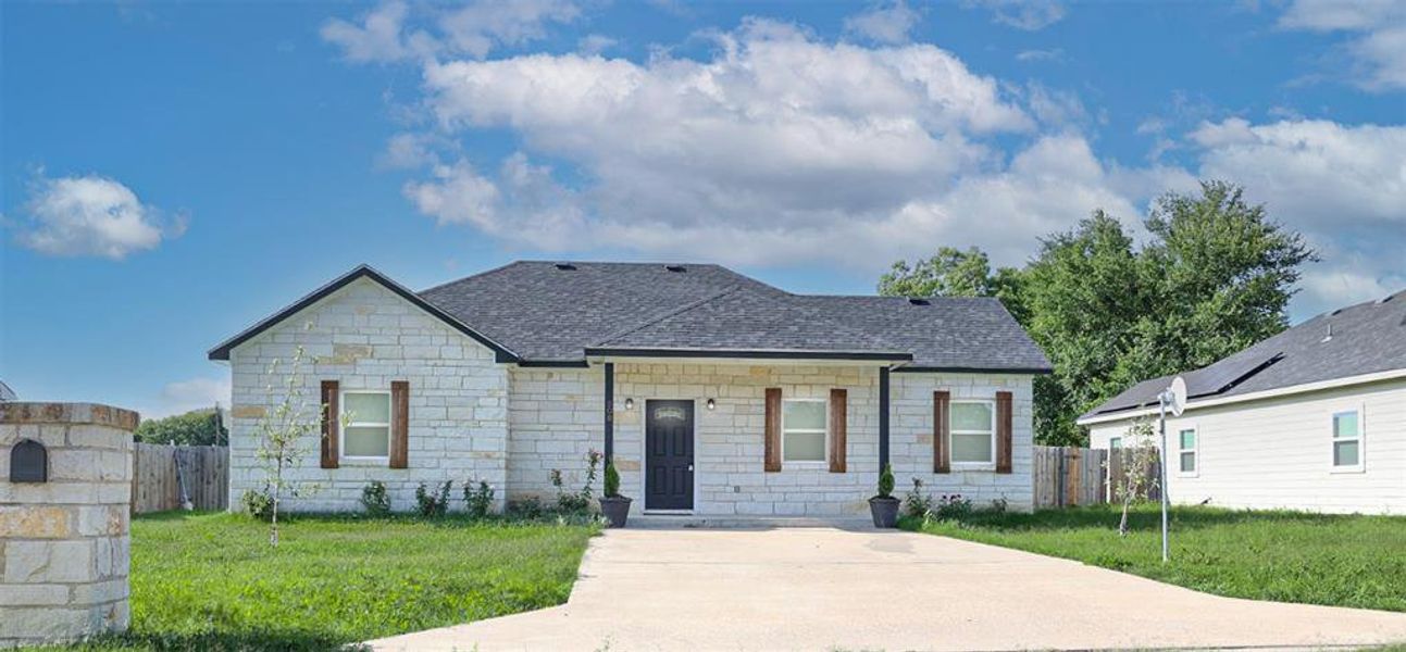 View of front of property featuring roof with shingles and stone siding