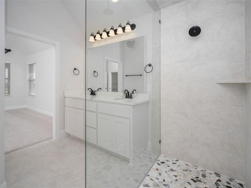 Full bathroom featuring double vanity, walk in shower, and light tile patterned flooring Full bathroom featuring double vanity, walk in shower, and light tile patterned flooring