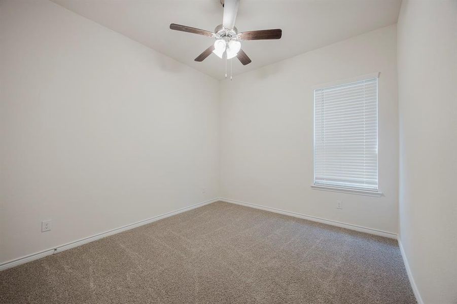 Unfurnished room featuring carpet floors and ceiling fan