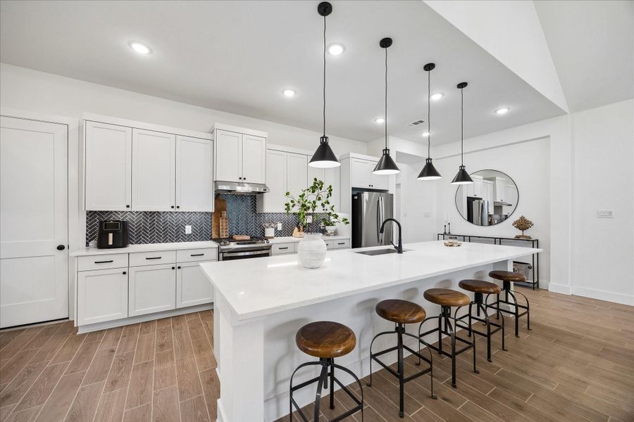 Gourmet island kitchen featuring J-Kraft custom cabinets, quartz countertops, and matte black hardware. Highlights include designer pendant lighting, stainless steel appliances, and a large island with plenty of space for seating. Gourmet island kitchen featuring J-Kraft custom cabinets, quartz countertops, and matte black hardware. Highlights include designer pendant lighting, stainless steel appliances, and a large island with plenty of space for seating.