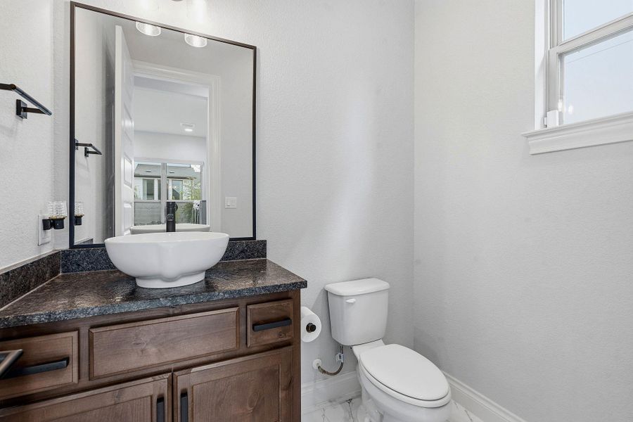 A well-appointed bathroom features a modern vessel sink, rich wood vanity, and a large mirror. A well-appointed bathroom features a modern vessel sink, rich wood vanity, and a large mirror.