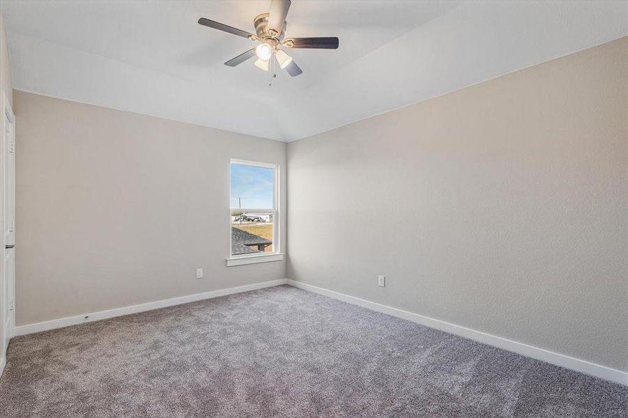 Bedroom featuring carpet flooring, ceiling fan, and lofted ceiling Bedroom featuring carpet flooring, ceiling fan, and lofted ceiling