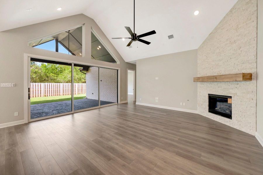 Gorgeous Family room with cathedral ceiling, corner fireplace and a wall of windows to accent it all!