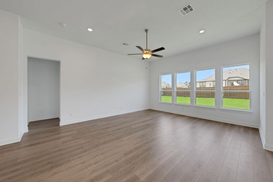 Empty room with recessed lighting, a ceiling fan, wood finished floors, and a residential view