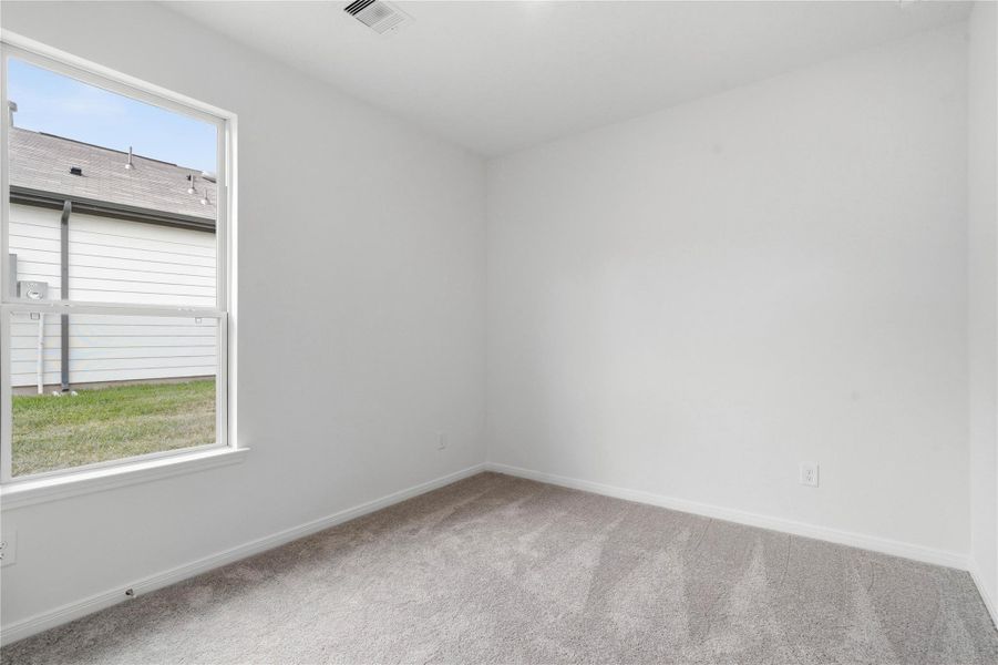 Light-filled secondary bedroom complete with cozy carpet flooring, ample closet space, and a large window. Light-filled secondary bedroom complete with cozy carpet flooring, ample closet space, and a large window.