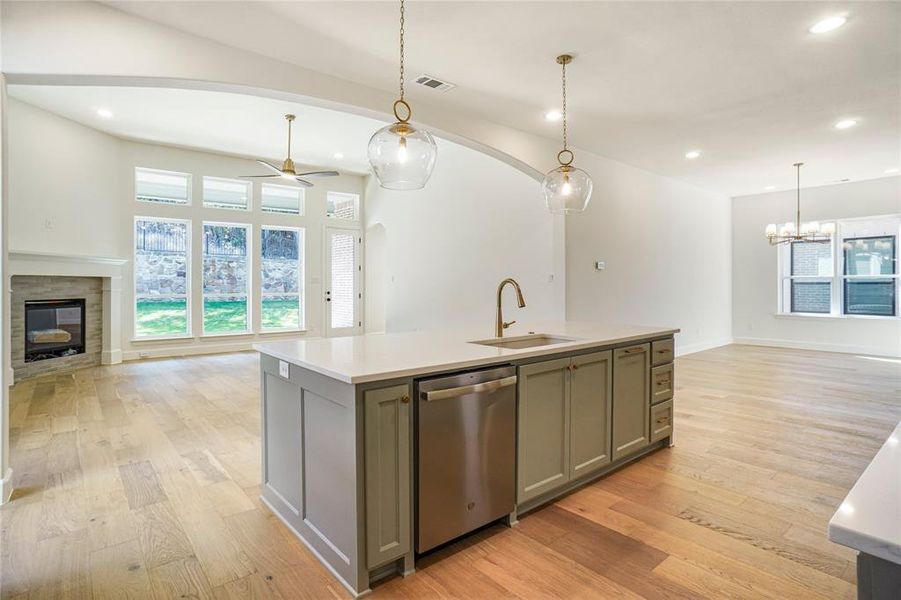 Kitchen with open floor plan, an island with sink, recessed lighting, gray cabinets, and stainless steel dishwasher