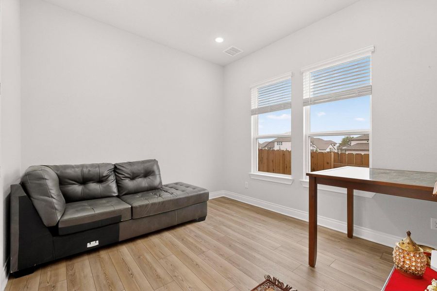 Sitting room with light wood-type flooring and recessed lighting