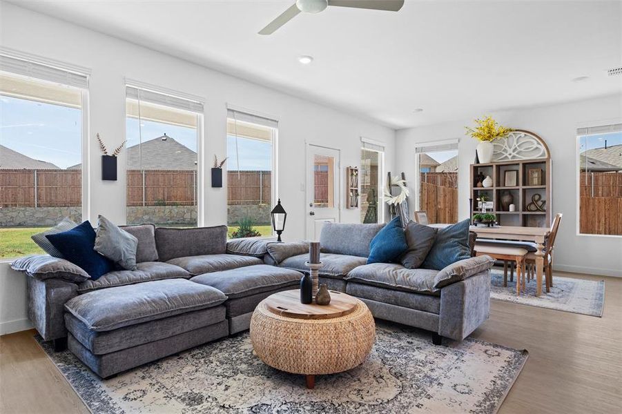 Living room with LVP finished floors, ceiling fan, and plenty of natural light Living room with LVP finished floors, ceiling fan, and plenty of natural light