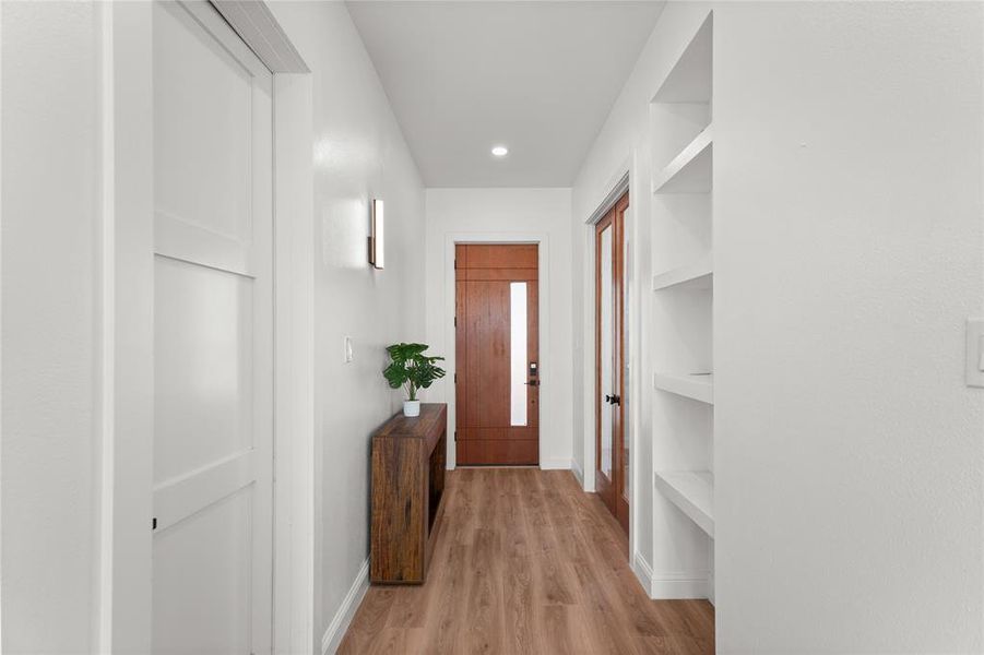 Doorway featuring wood finished floors, built in features, and recessed lighting