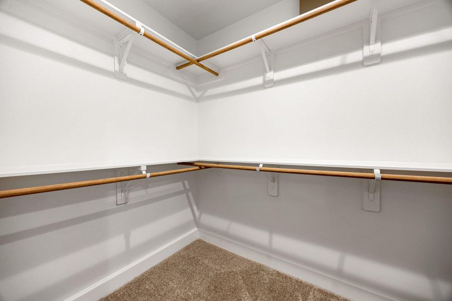 Spacious closet featuring double hanging rods and open shelving, offering plenty of storage space and easy organization. Clean, functional, and well-designed for everyday use.