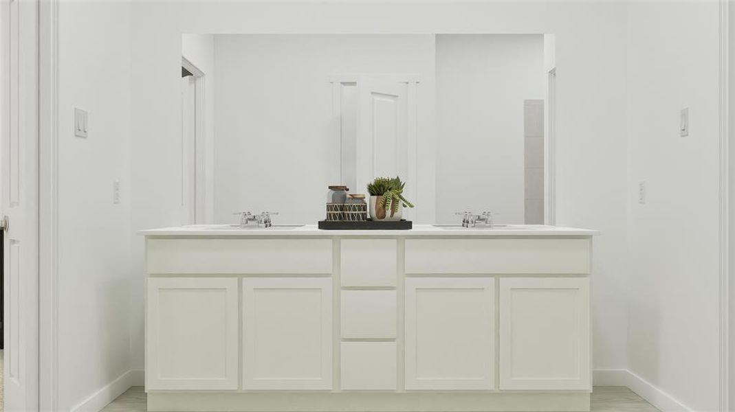 Full bath with double vanity and baseboards