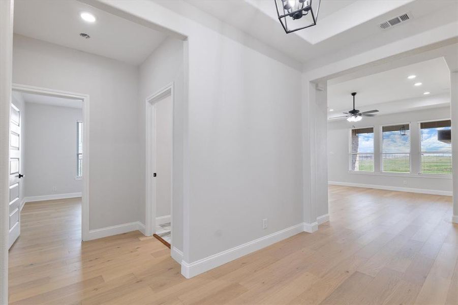 Hallway featuring baseboards, visible vents, and light wood-style floors