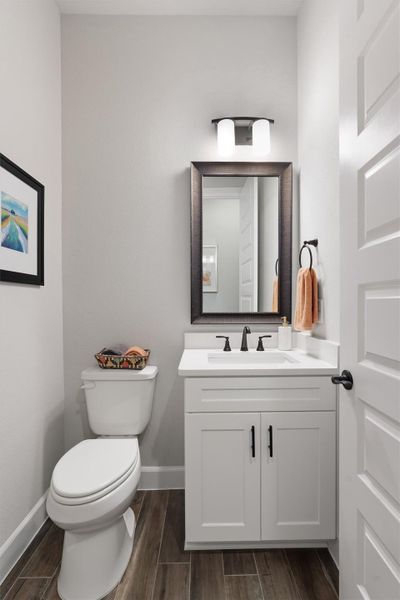Half bath with vanity, quartz countertop and wood-look tile flooring. Half bath with vanity, quartz countertop and wood-look tile flooring.