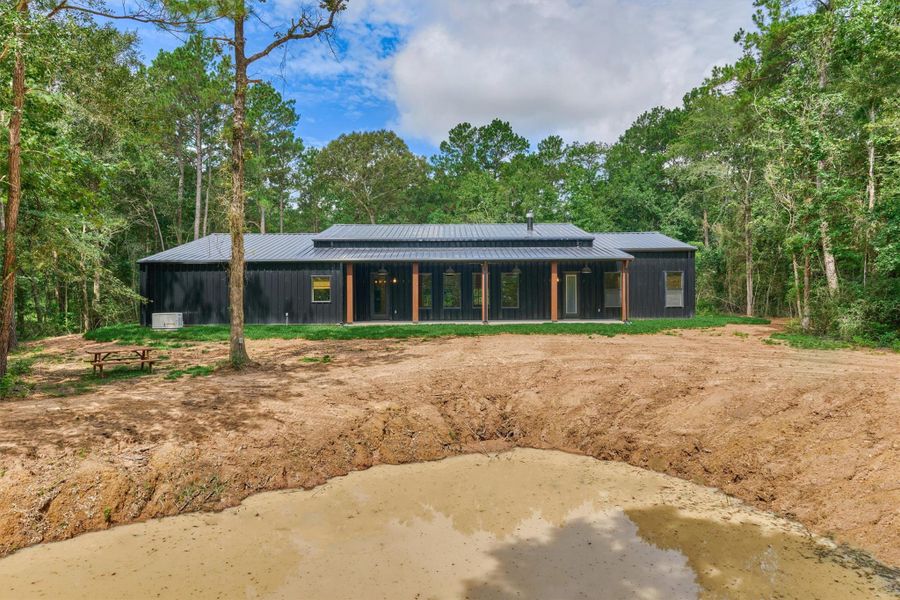 This view from the back of the property looking toward the home showcases the abundance of mature trees