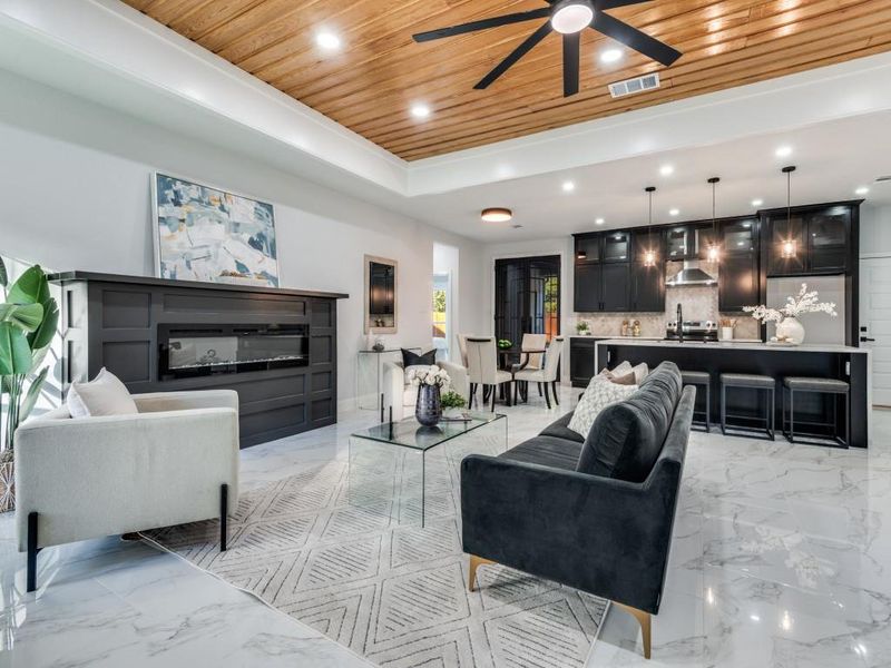 Living room featuring wooden ceiling, recessed lighting, ceiling fan, light marble finish flooring, and a raised ceiling