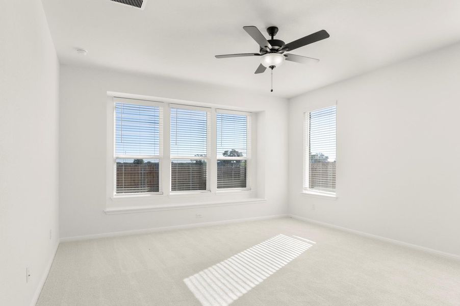 Spare room with light carpet and a ceiling fan
