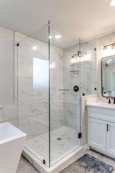 Bathroom featuring tile patterned flooring, vanity, tile walls, and independent shower and bath