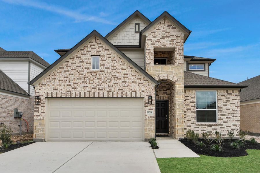 Meticulously maintained yard and lush landscape, paired with a premium elevation featuring captivating brick accents. Modern coach lights add a touch of contemporary elegance to the exterior.