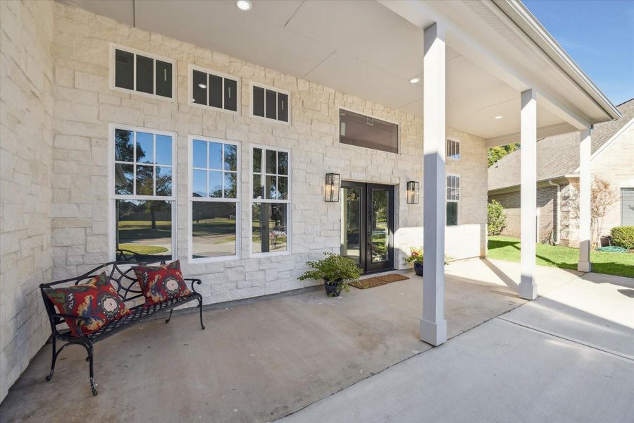 An inviting Veranda spanning the width of the front entry just beyond a triple wide Driveway.